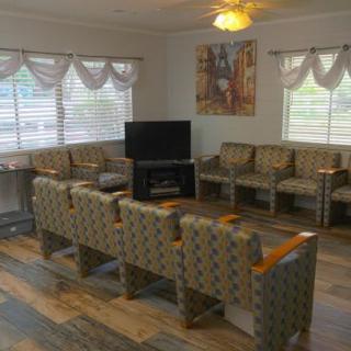 An empty waiting room with patterned chairs and a television.