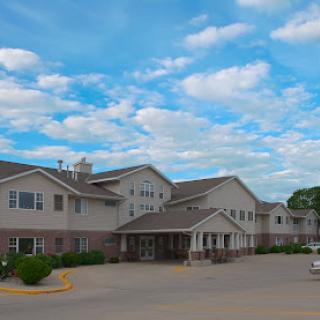 A pleasant residential building under a bright blue sky with fluffy clouds.