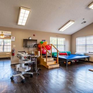 A rehabilitation room equipped with exercise equipment and therapy tools.