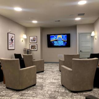 A cozy home theater room with comfortable seating and a large TV.