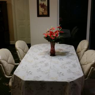 A dining table with a floral centerpiece in a well-lit room.