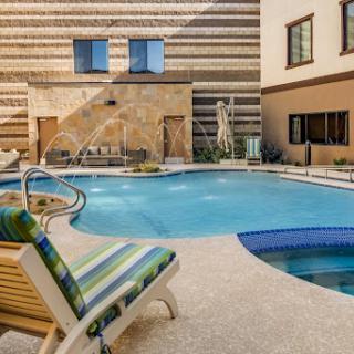 A serene outdoor pool area featuring comfortable lounge chairs and stylish modern architecture.