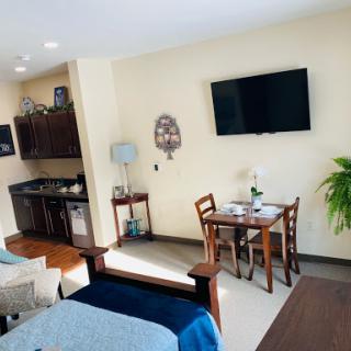 Cozy studio apartment featuring a kitchenette, dining area, and comfortable furnishings.
