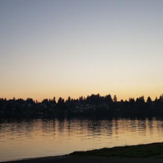 A tranquil sunset over the lake, casting reflections on the water.