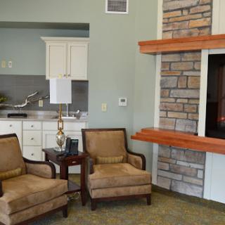 A cozy living room setup featuring two comfortable chairs beside a stylish stone fireplace.