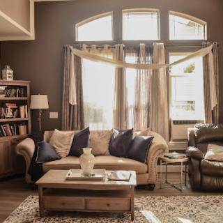 A warm and inviting living room filled with natural light, featuring a comfortable sofa and a wooden coffee table.