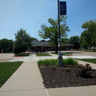 A view of a building surrounded by well-maintained landscaping and a clear blue sky.