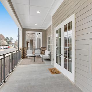 A stylish balcony featuring comfortable seating and a bright, inviting atmosphere.