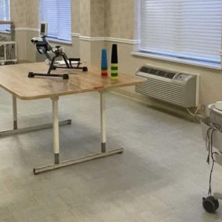A physical therapy room with exercise equipment and a treatment table.