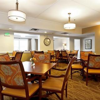 A well-lit dining area featuring multiple tables and chairs in a cozy setting.