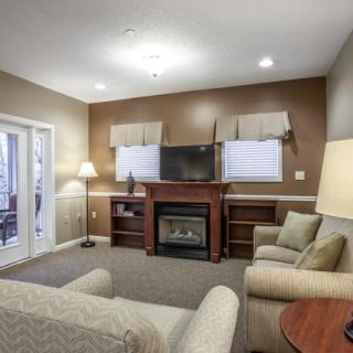 A cozy living room featuring a fireplace, television, and comfortable seating.