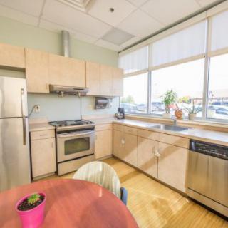 A bright and modern kitchen featuring stainless steel appliances and large windows that let in plenty of natural light.