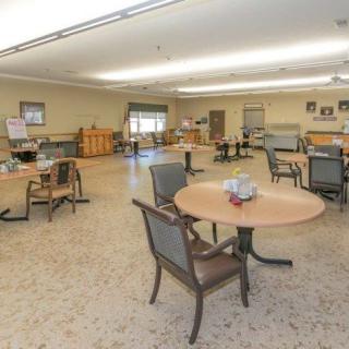 An empty dining room with several tables and chairs arranged neatly.