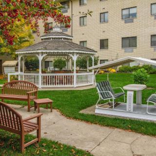 A serene outdoor garden featuring a gazebo and comfortable seating, perfect for relaxation.