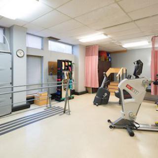 A fitness room equipped with various exercise machines and rehabilitation tools.