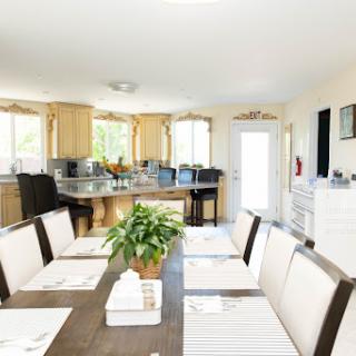 A bright and spacious dining area featuring a modern table, comfortable chairs, and a touch of greenery.