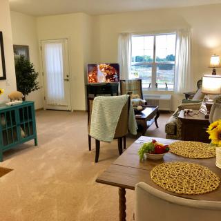 A cozy living room with comfortable furniture, a television, and a dining area.