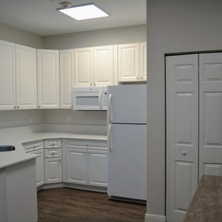 A modern kitchen with white cabinets and appliances.