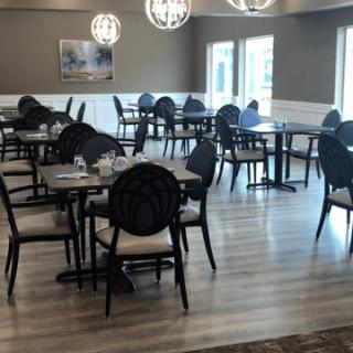 A modern restaurant dining area with empty tables and stylish decor.