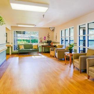 A bright and spacious lobby with comfortable seating, indoor plants, and large windows.