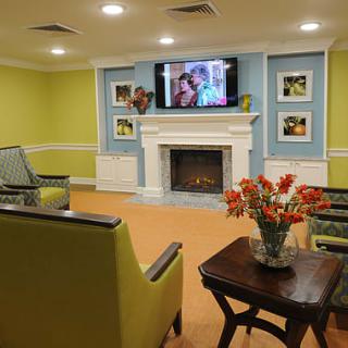 A cozy living room with modern decor, featuring a fireplace, television, and comfortable seating.