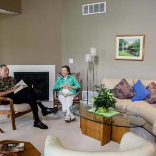 Two people sitting in a cozy living room engaged in conversation.