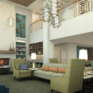 A modern living room with elegant furniture, featuring a chandelier and a cozy fireplace.