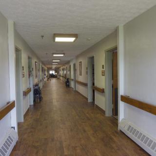 A long corridor inside a building, likely a hospital or healthcare facility.