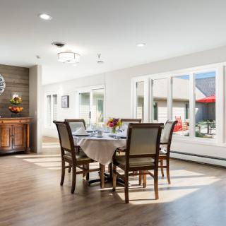 Bright dining room with a set table and large windows allowing natural light.