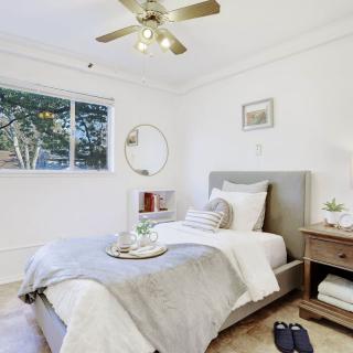 A cozy minimalist bedroom with a single bed, nightstand, and decorative elements.