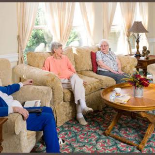A group of seniors enjoying a conversation in a cozy living room setting.
