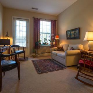 A cozy living room featuring a sofa, lamps, and a decorative rug.