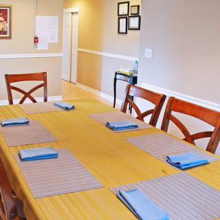 A neatly set dining table with placemats and napkins in a cozy dining room.