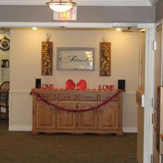 A warmly decorated interior space with a love-themed setup, featuring a wooden cabinet adorned with red decorations and Valentine's Day elements.