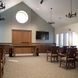 A well-designed interior room featuring a wooden podium, chairs, and modern lighting.