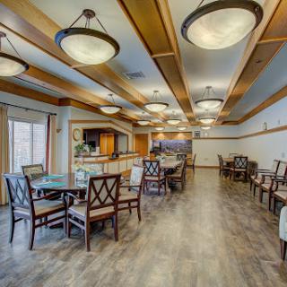 A spacious and elegantly designed dining area with modern furniture and warm lighting.