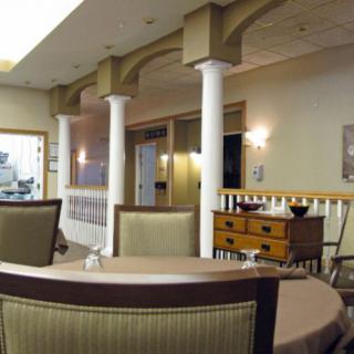 A dining area with columns and multiple tables set for meals.