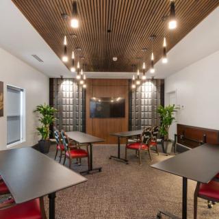 A modern conference room with stylish lighting and a wooden ceiling.