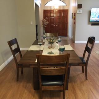 A cozy dining area featuring a wooden table set with chairs and simple decor.
