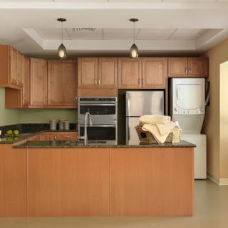 A modern kitchen featuring wooden cabinetry, sleek appliances, and a spacious layout.