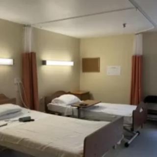 A hospital room with two beds, ready for patient care.