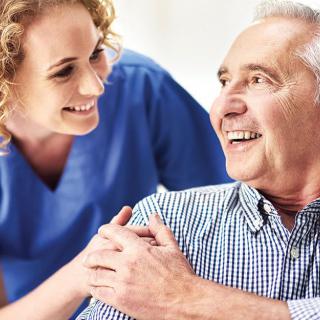 A nurse interacting warmly with an elderly man, showcasing a supportive and caring environment.
