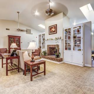 A spacious living room featuring comfortable seating, a central fireplace, and built-in bookshelves.