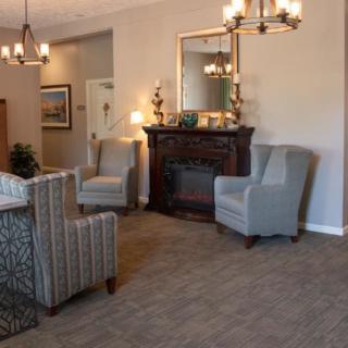 A cozy living room with armchairs, a fireplace, and elegant decor.