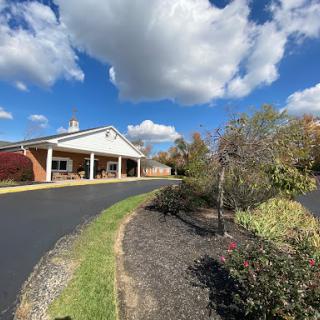 A peaceful view of a building surrounded by greenery and a clear blue sky.
