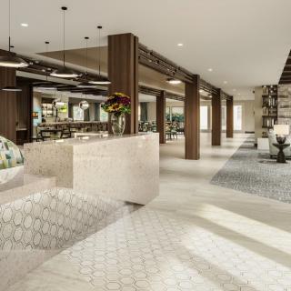 A modern lobby with a reception desk, stylish furniture, and elegant lighting.
