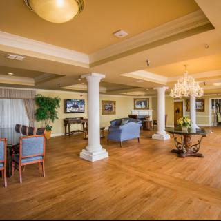 Spacious and elegantly decorated lobby with seating and a chandelier.