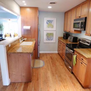 A modern kitchen with wood cabinets and stainless steel appliances.
