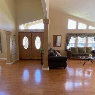 Spacious living room with wooden floors and large windows.