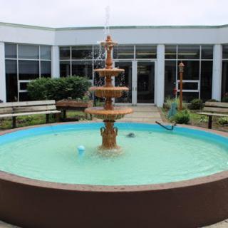 A beautiful fountain surrounded by benches in a serene courtyard.